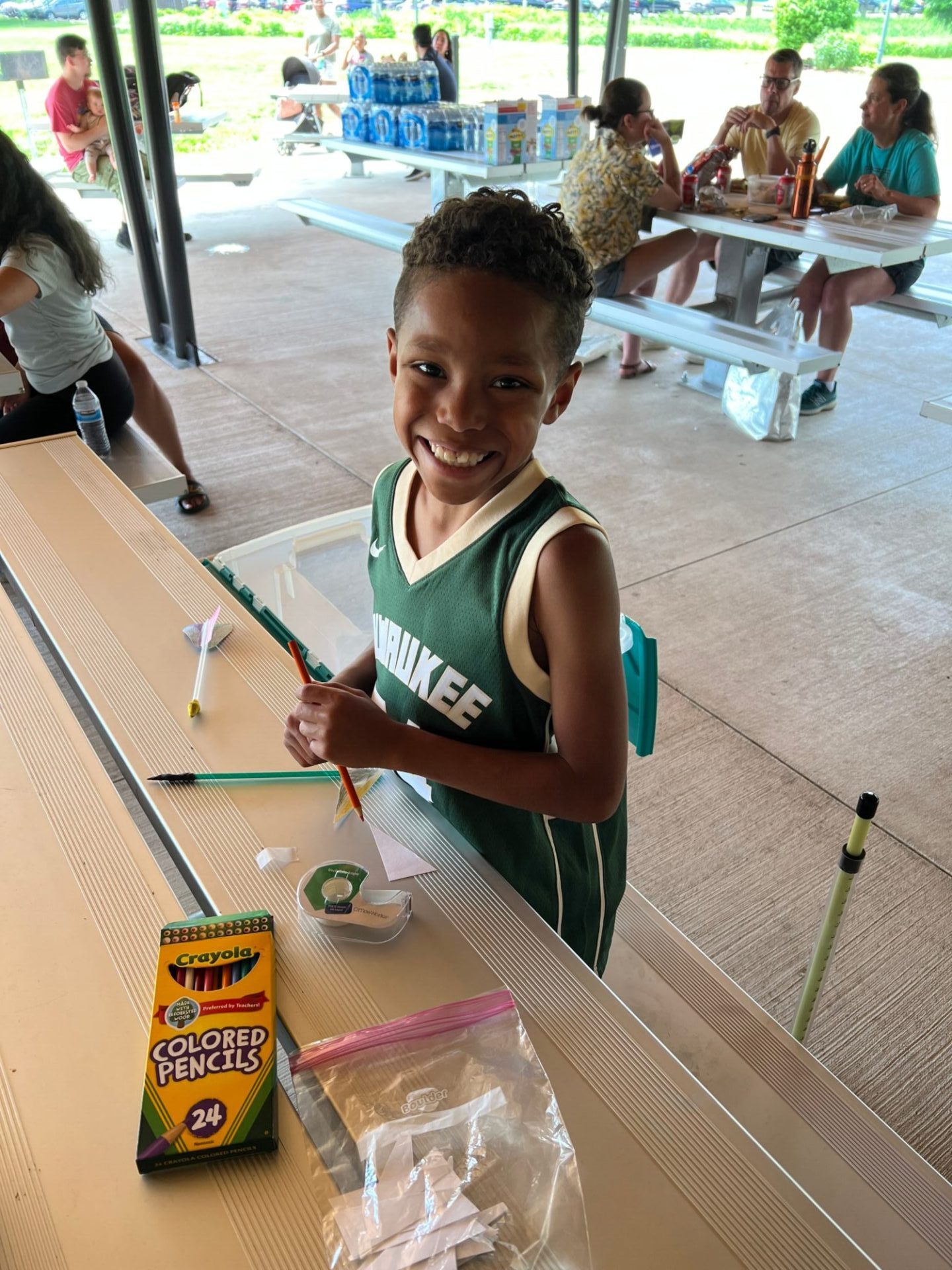 little boy smiling and coloring