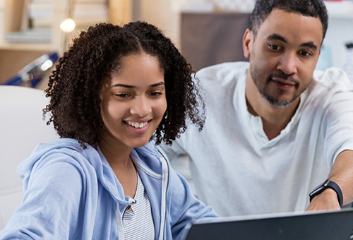 Father and daughter working with their laptop