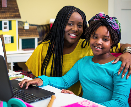 Mother and daughter working with their laptop